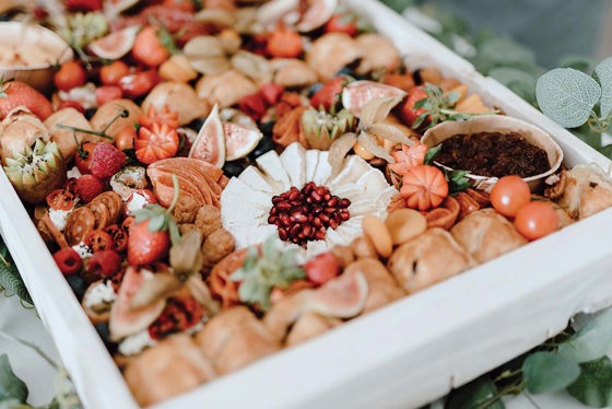 Grazing selection in white box with cheese, meat, fruits and chutney